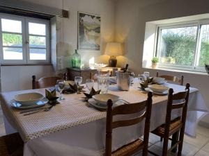 a dining room table with a white table cloth and chairs at Gites de Gondières in Saint-Éloi