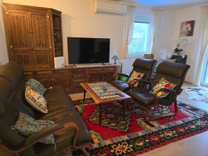 a living room with a couch and chairs and a tv at Apartment Maja in Labin