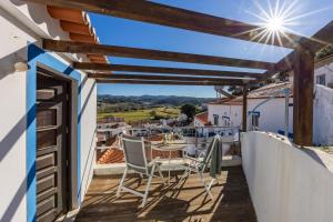 a balcony with a table and chairs and a view at Casa Azul - Aljezur Town in Aljezur