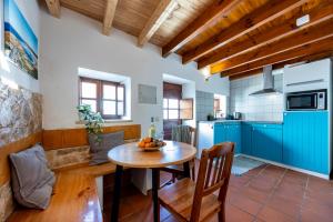 a kitchen with blue cabinets and a wooden table at Casa Azul - Aljezur Town in Aljezur