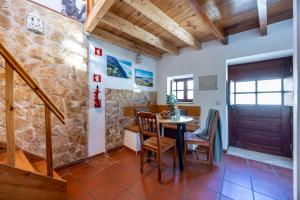 a room with a table and chairs and a stone wall at Casa Azul - Aljezur Town in Aljezur
