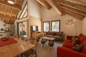 Una sala de estar con un sofá rojo y una mesa. en Chalet Le Strato, en Valloire