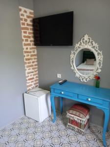 a blue dressing table with a mirror on a wall at Casa Magnolia Boutique Rooms in Kuşadası