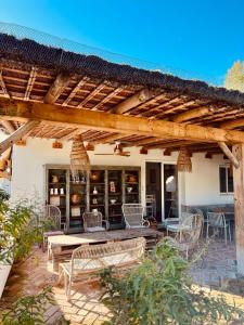 a patio with a table and chairs under a wooden pergola at La Finca de Véro in Barbate