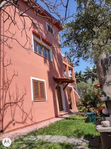 a pink house with a staircase leading up to it at Casa vacanze Villa Marcella in Maratea