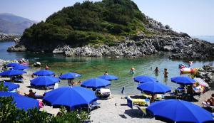 a group of people on a beach with blue umbrellas at Casa vacanze Villa Marcella in Maratea +7 photos