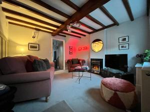 a living room with a couch and a fireplace at Boutique style cosy cottage in Ellesmere