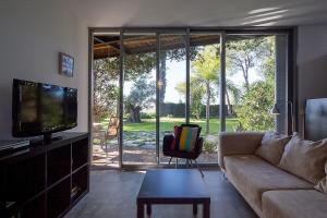 Μια τηλεόραση ή/και κέντρο ψυχαγωγίας στο 1BR Apartment in the heart of nature near Seville with swimming pool and parking