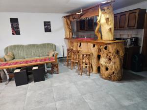 a living room with a table and a large tree stump at Casa de vacanța Marin in Arpaşu de Sus