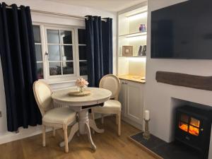 ein kleines Esszimmer mit einem Tisch und einem Kamin in der Unterkunft Stunning Cottage in Knutsford by City SuperHost in Knutsford