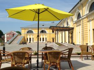 un tavolo con un ombrello giallo di fronte a un edificio di Rothko Museum residences a Daugavpils