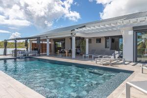 a swimming pool in the backyard of a house at Villa Mélina in Capesterre-de-Marie-Galante