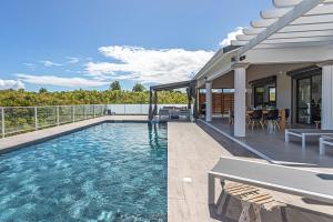 a house with a swimming pool on a balcony at Villa Mélina in Capesterre-de-Marie-Galante