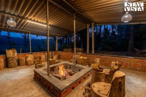a patio with a fire pit in the middle at The Rivernook - The perfect place for getaways in Jambur