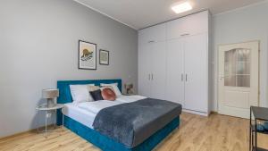 a bedroom with a bed with a blue head board at Szczytnicka, Sun & Snow in Wrocław