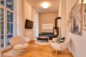 a living room with two chairs and a fireplace at Ferienwohnung DuNord Putbus in Putbus