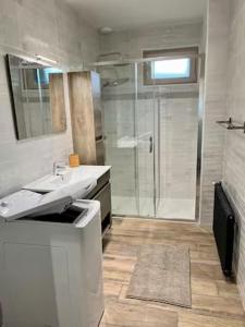 a bathroom with two sinks and a glass shower at Chez Yvonne in Neuf-Église