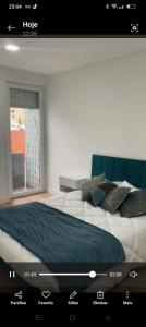 a bedroom with a large bed with a window at Apartamento T3 remodelado in Barcelos