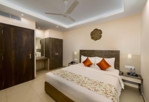a bedroom with a large white bed with orange pillows at Hotel White Rose IGI Airport in New Delhi +4 photos