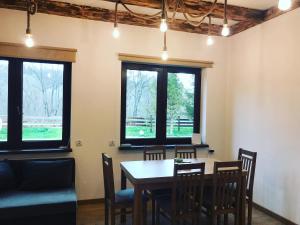 a dining room with a table and chairs and windows at Bieszczadzki Luz in Dwernik