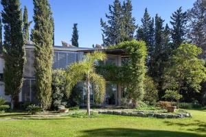 una casa con una palmera en el patio en Loft surrounded by nature next to Seville with swimming pool and parking, en Espartinas