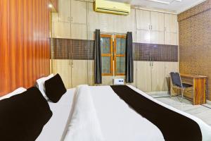 ein Schlafzimmer mit einem Bett, einem Schreibtisch und einem Stuhl in der Unterkunft Hotel O S&R Haven in Kānpur