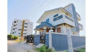 a blue and white house with a fence at Vintage Luxury Bungalow in Puducherry