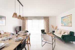a dining room and living room with a table and chairs at La Belle de Fréhel - Jolie maison avec jardin in Frehel