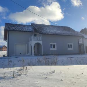 a large white house with a roof at Studio apartman Čolić in Kupres
