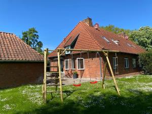 a house with a playground in the yard at Gut Koselau Landhaus III in Koselau