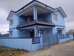 a blue house with a balcony at Ooty Blue Mountain Villa Thalayathimund in Ooty