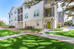 an apartment building with a green door and grass at Stylish Home Perfect for Your Stay in Leander