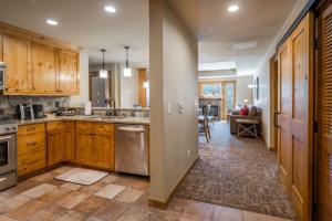 a kitchen with wooden cabinets and stainless steel appliances at Suncadia Trailhead 1 Condo 208 in Cle Elum