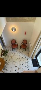 a room with two chairs sitting on a tile floor at La Maison du Jardin in Linars