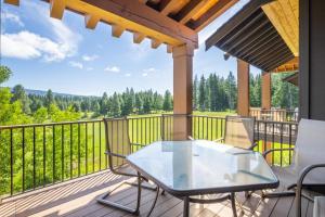 een patio met een glazen tafel en stoelen op een terras bij Suncadia Trailhead 1 Condo 303 in Cle Elum