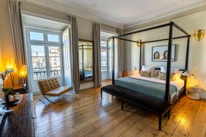 a bedroom with a canopy bed and a chair at Le Consulat in Lisbon
