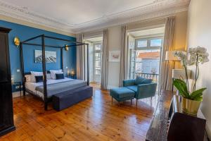 a bedroom with a bed and a couch and a chair at Le Consulat in Lisbon