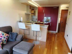 a living room with a couch and a kitchen at El apartamento de Noe in Berrón +21 photos