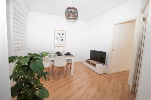 a white living room with a table and a tv at Lujoso Apartamento en Valencia 3 Dormitorios con Parking in Paterna