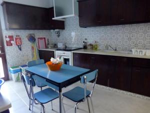 a kitchen with a blue table and chairs in it at Casa Tangerina in Tavira +26 photos