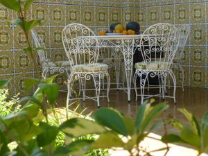 a table with chairs and fruit on top of it at Casa Tangerina in Tavira