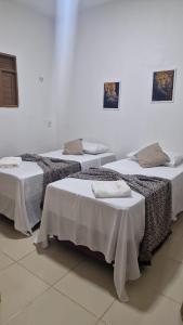 eine Gruppe von 3 Betten in einem Zimmer in der Unterkunft Casa de Praia Toca da Onça in São Miguel do Gostoso