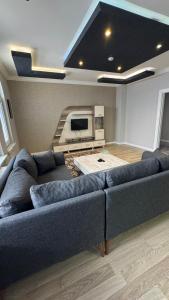 a living room with a couch and a tv at MİLENYUM HOUSE SUİT in Ankara