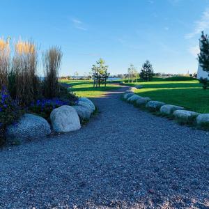 a gravel path in a park with rocks and flowers at Beachfront cosy apartment in Tønsberg