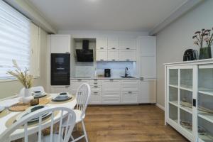 a kitchen with white cabinets and a table and chairs at Apartment Tullikatu in Kristinestad