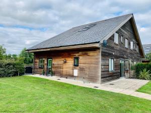 ein großes Holzhaus mit großem Hof in der Unterkunft Libelle Lodge in South Cerney
