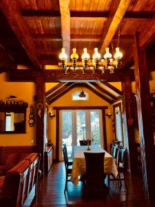 a dining room with a table and chairs and a chandelier at Chalet d'Argent in Dobreni