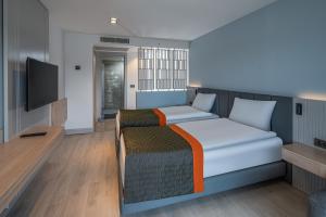 a bedroom with a bed and a flat screen tv at Swandor Hotels & Resorts - Kemer in Kemer