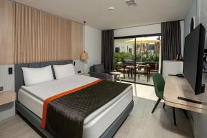 a bedroom with a bed and a desk and a television at Swandor Hotels & Resorts - Kemer in Kemer
