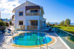 a villa with a swimming pool and a house at Villa Bella Ena in Nea Dimmata